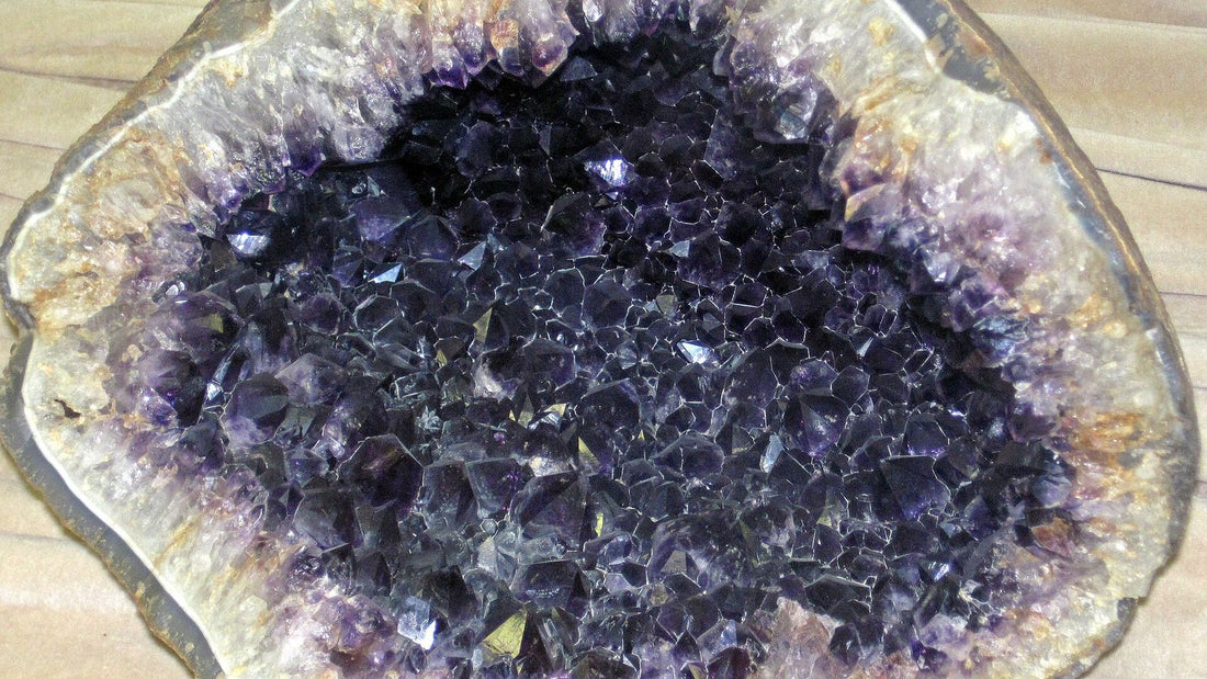 Aufgeschnittene Amethystgeode mit dunkelvioletten Kristallen, die nach innen zeigen