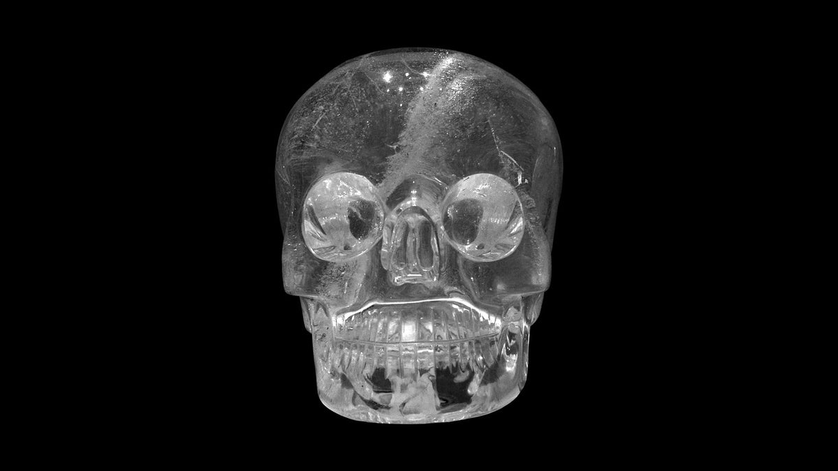 Der Kristallschädel des British Museum, lebensgroß aus Bergkristall geschliffen, vor schwarzem Hintergrund