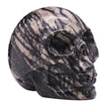 Edelstein-Totenkopf aus dunklem Netzstein, klein, seitliche Ansicht
